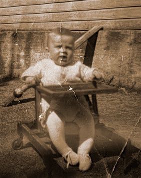​Baby in wheelchair 1950s 
